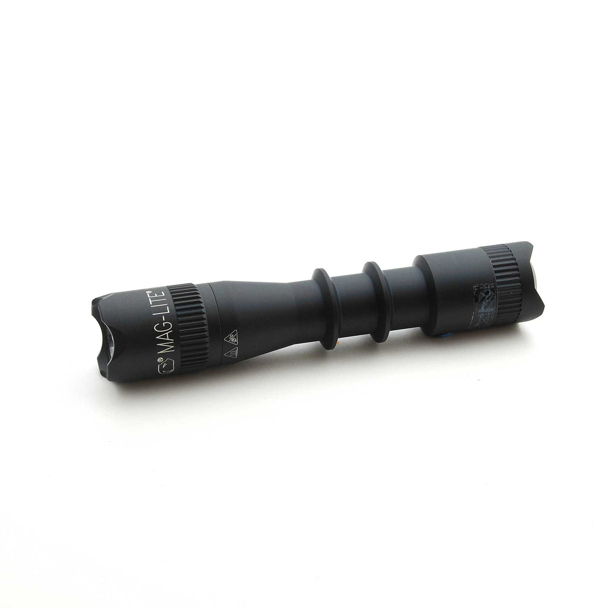 Black Mag-Tac 2TM tactical flashlight with knurled grip and crown bezel on white background