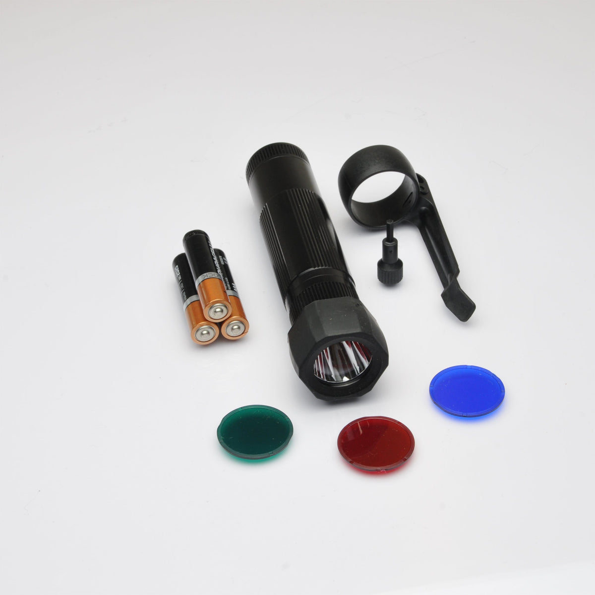 Black XL50 LED tactical pack components with orange Duracell AA batteries and caps on white background
