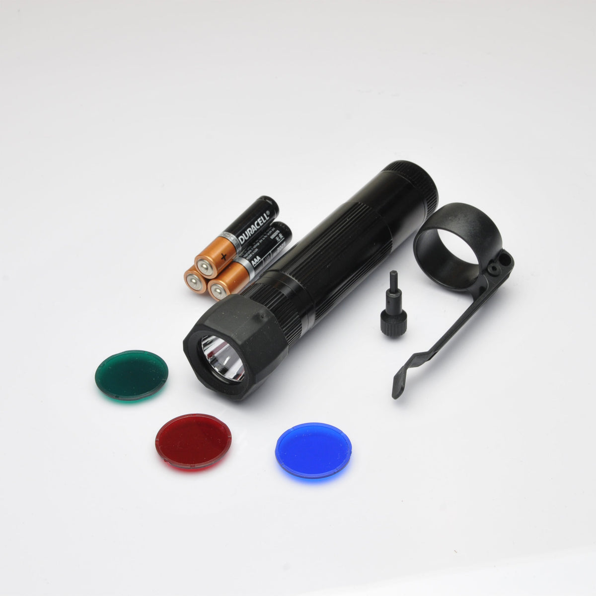 Duracell AA batteries beside a black XL50 LED tactical flashlight with mounting bracket and assorted color lens caps nearby