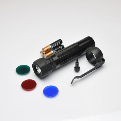 XL50 LED tactical flashlight with mounting bracket and Duracell batteries beside scattered color lens caps