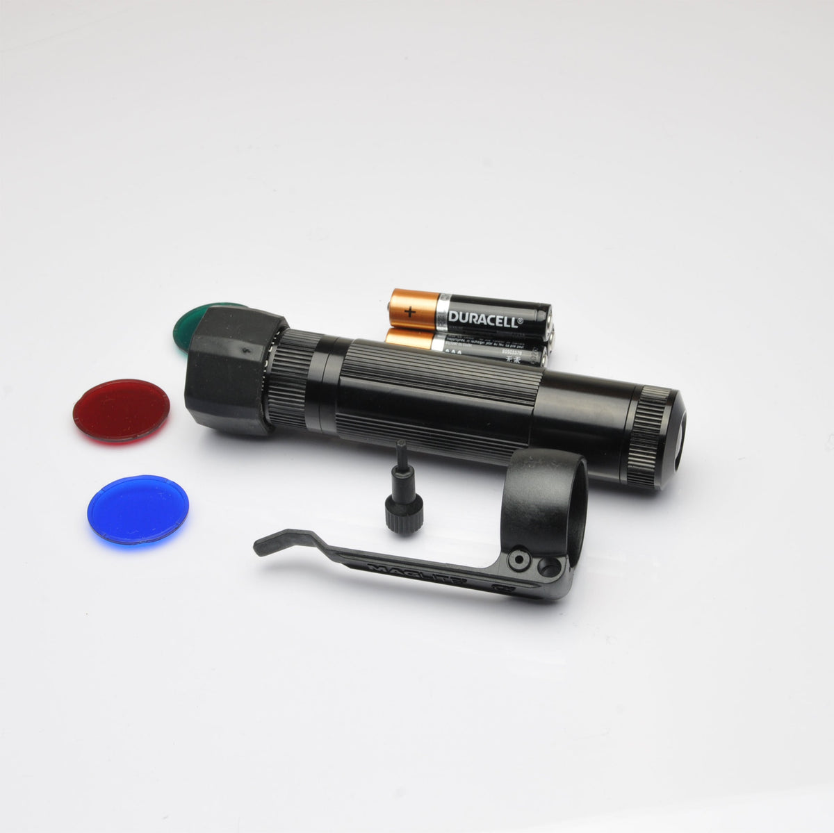 Blue and red lens caps with the Maglite XL50 LED tactical flashlight and mounting bracket on white surface