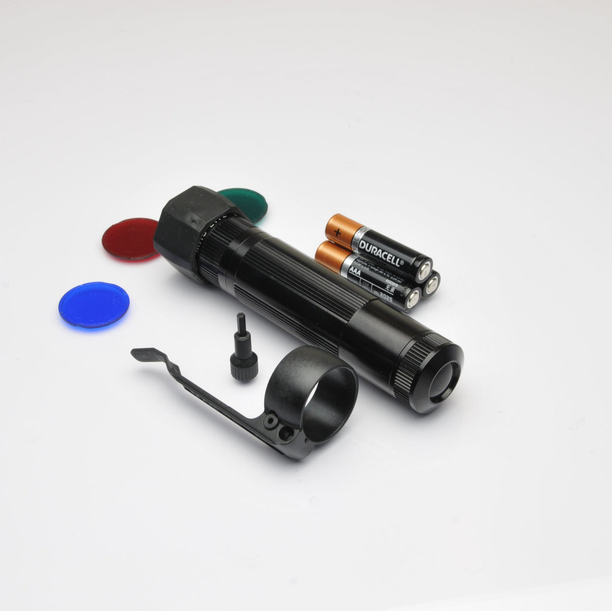 XL50 LED tactical flashlight with green end cap and orange Duracell AAA batteries on a white background