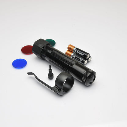 XL50 LED tactical flashlight with green end cap and orange Duracell AAA batteries on a white background