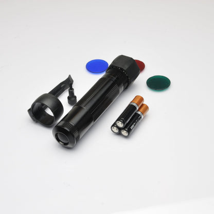 Black XL50 LED tactical flashlight with blue red and green filter discs on white background