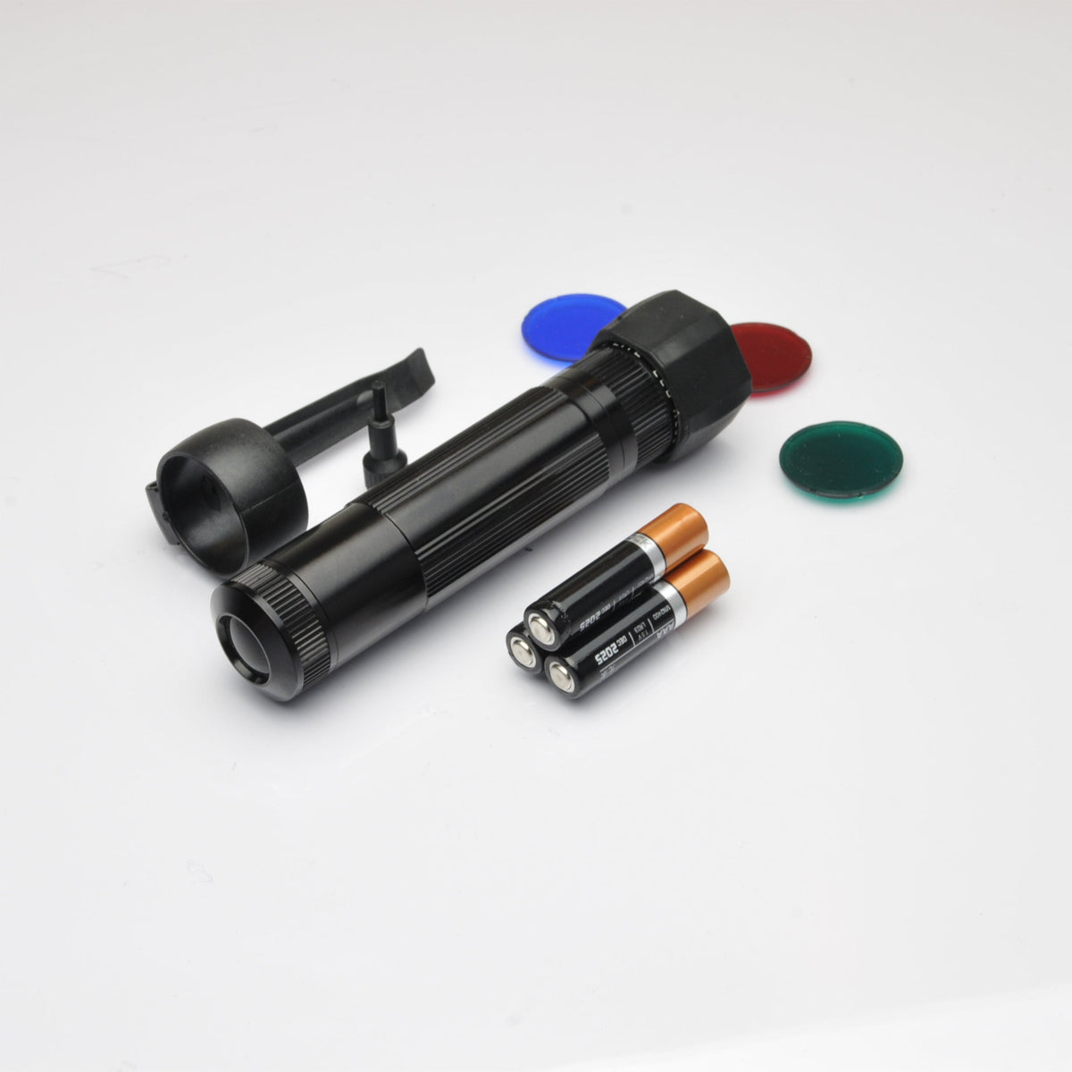 Black XL50 LED tactical flashlight with blue filter cap visible and red and green discs nearby