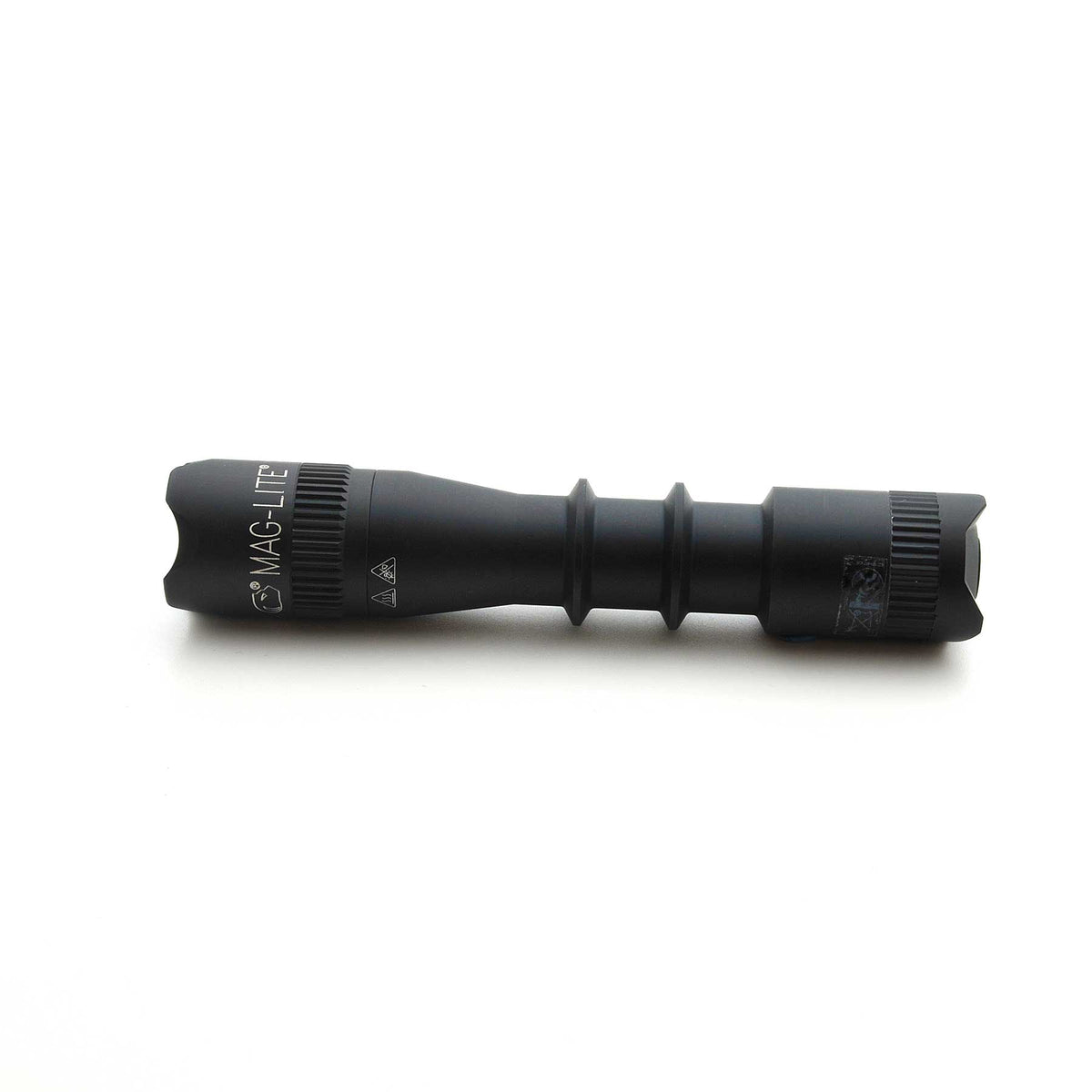 Side view of black MAG-TAC flashlight showing branding and ridged grip