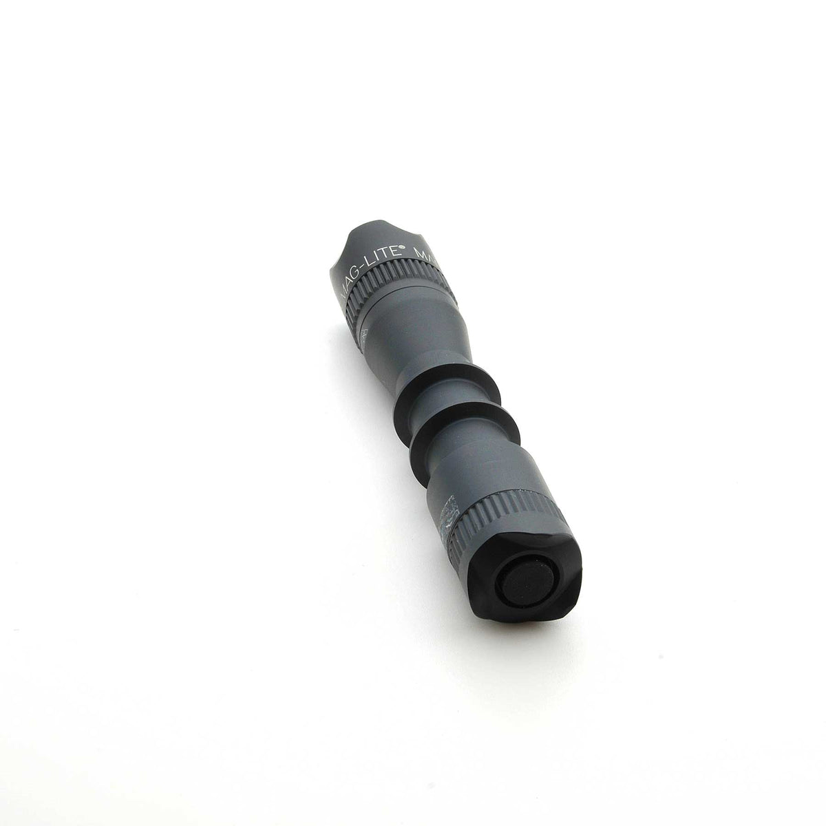 Angled view of MAG-TAC 2 TM black crown bezel with knurled ring on a flashlight
