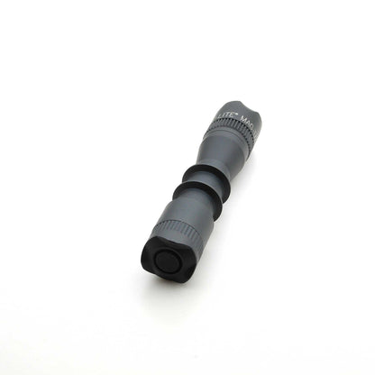 Close-up of MAG-TAC 2 TM Black Crown Bezel with knurled ring on a gray cylindrical body
