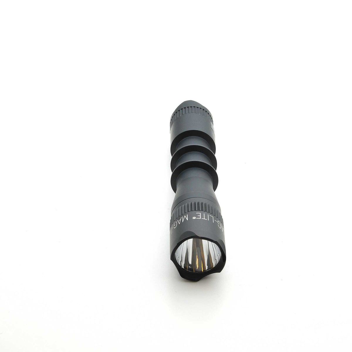 Front end of black MAG-TAC 2 TM crown bezel flashlight with clear lens and visible internal reflector.
