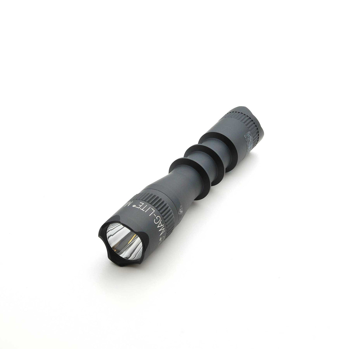 Angled shot of MAG-TAC 2 flashlight with black crown bezel and knurled grip