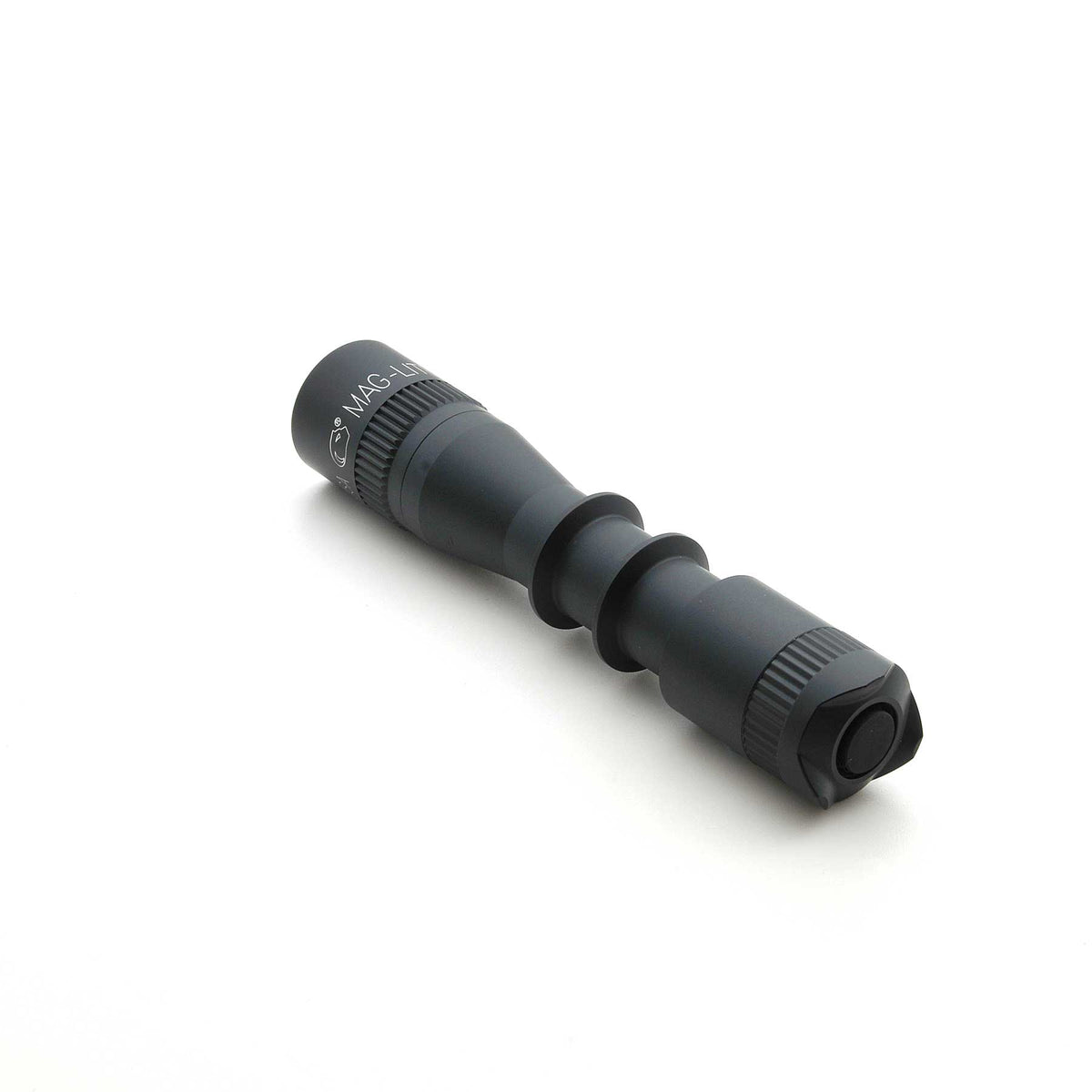 Close up of MAG-TAC 2 TL Black plain bezel flashlight with knurled grip on white background