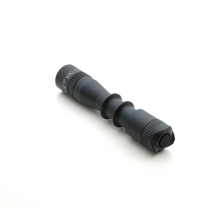 Close up of MAG-TAC 2 TL Black plain bezel flashlight with knurled grip on white background