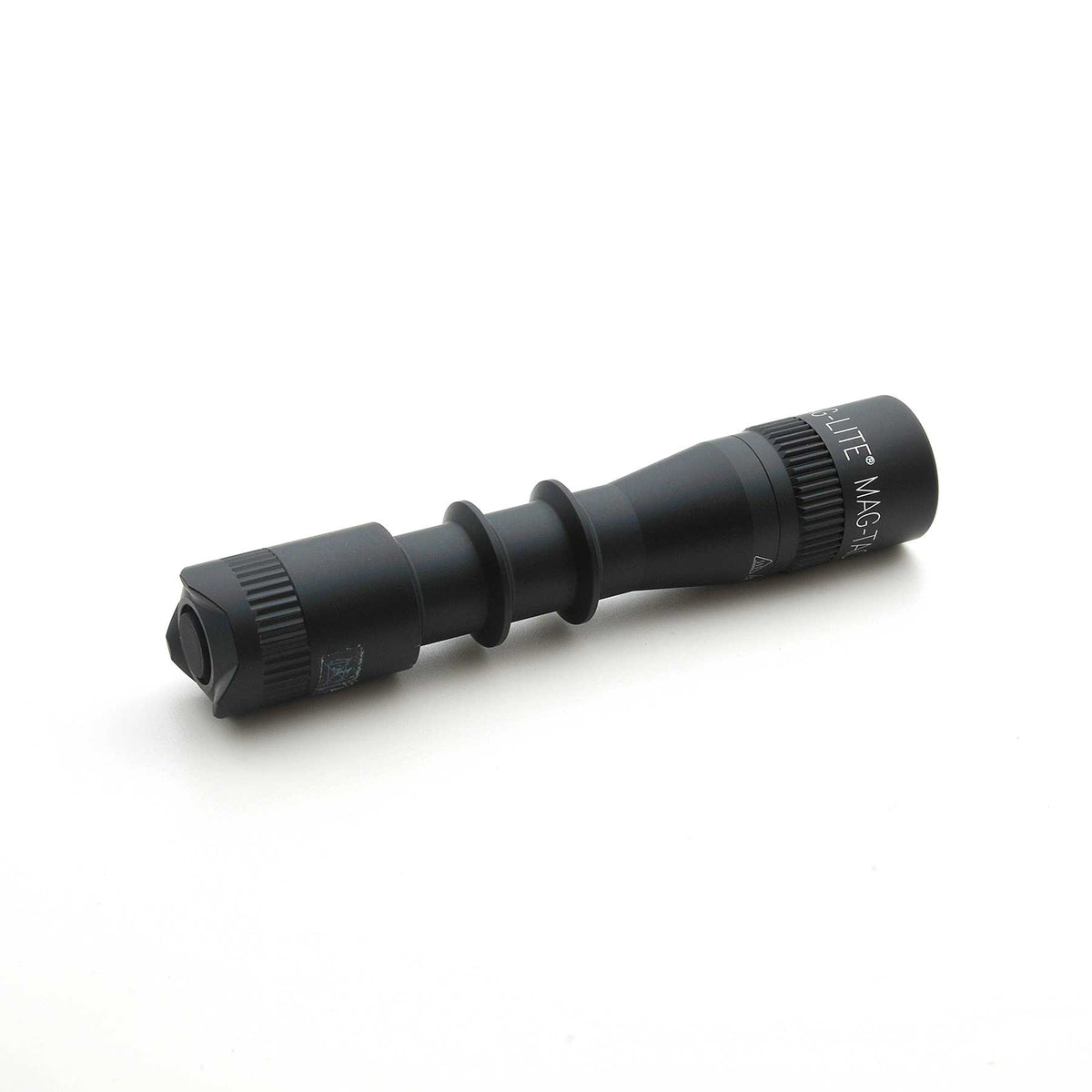 Close up of the MAG-LITE MAG-TAC 2 TL black flashlight with plain bezel, focusing on the knurled midsection.