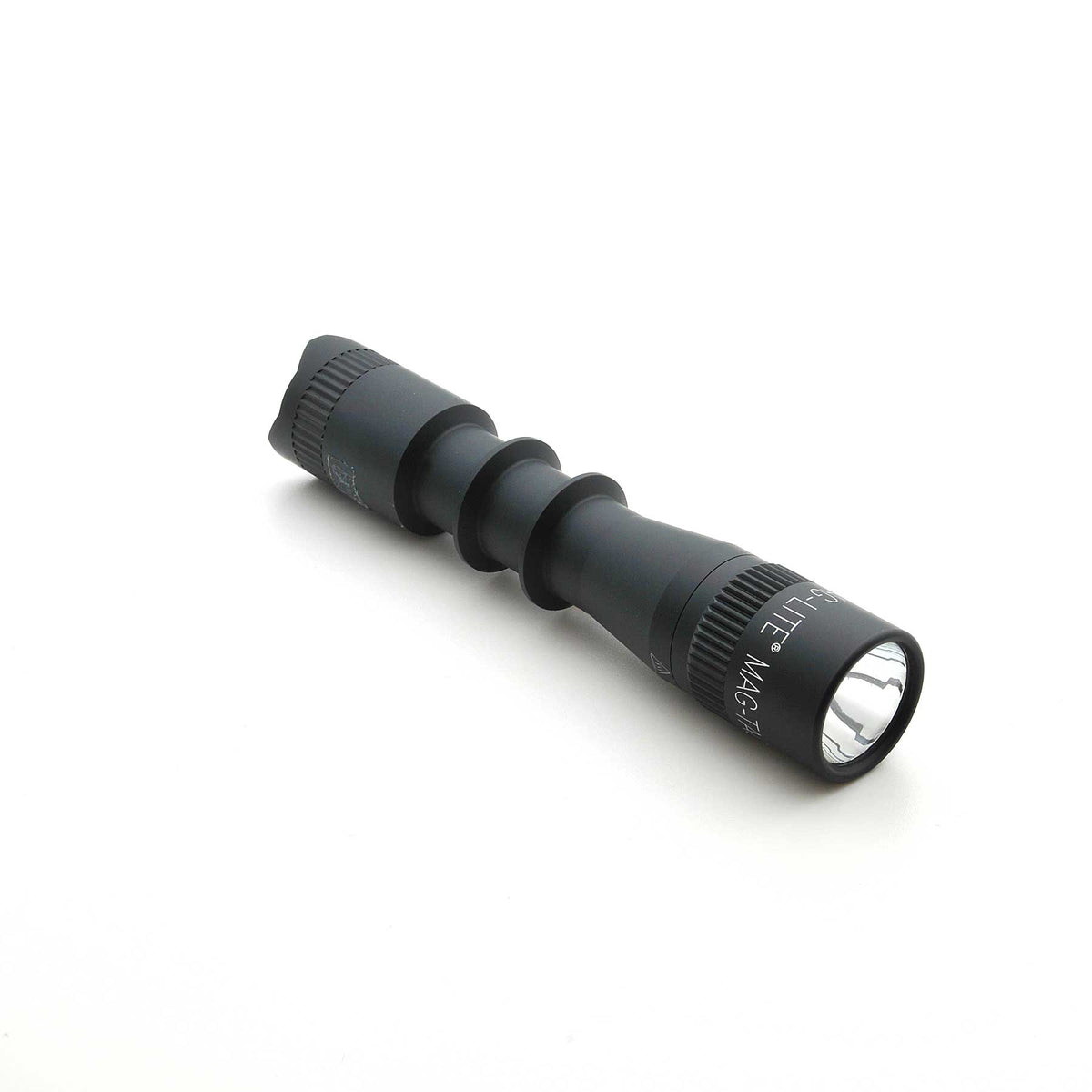 MAG-TAC 2 TL black tactical flashlight with plain bezel and knurled grip, angled on a white background.