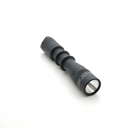 Close up of MAG-TAC 2 TL black tactical flashlight head with knurled bezel and matte finish.