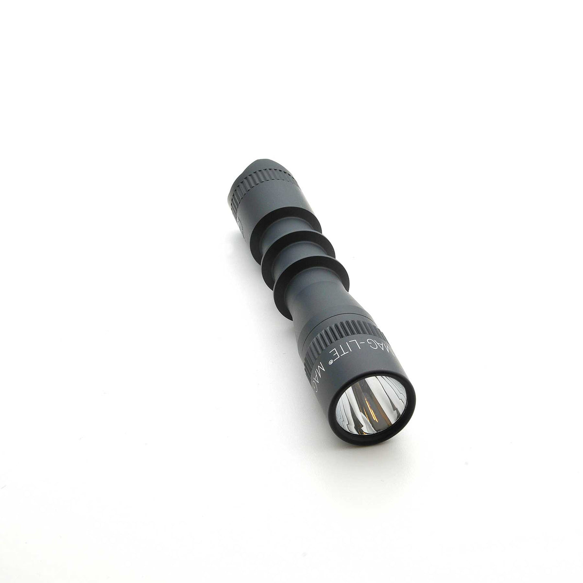 Front view of MAG-TAC 2 TL black flashlight showing clear lens and plain bezel.