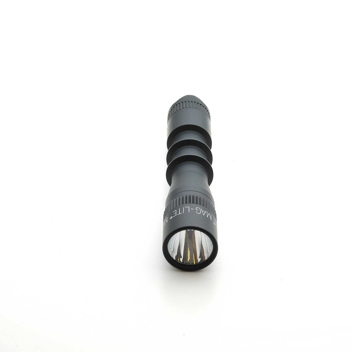 Close up of MAG-TAC 2 TL Black Plain Bezel flashlight showing knurled focus rings and front lens.