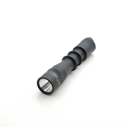 Angled view of MAG-TAC 2 TL Black Plain Bezel flashlight highlighting the ridged body and reflective lens.