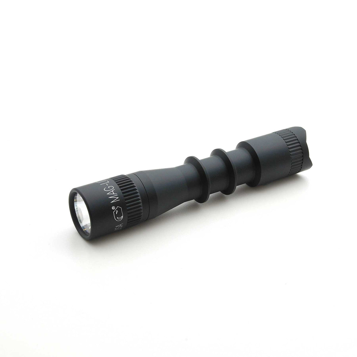 Side view of MAG-TAC 2 TL Black Plain Bezel flashlight showing knurled grip and markings