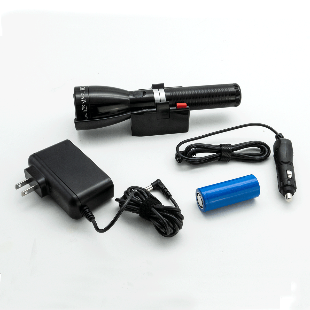 Side view of Maglite ML150LRSX flashlight in its charging cradle with a blue battery nearby
