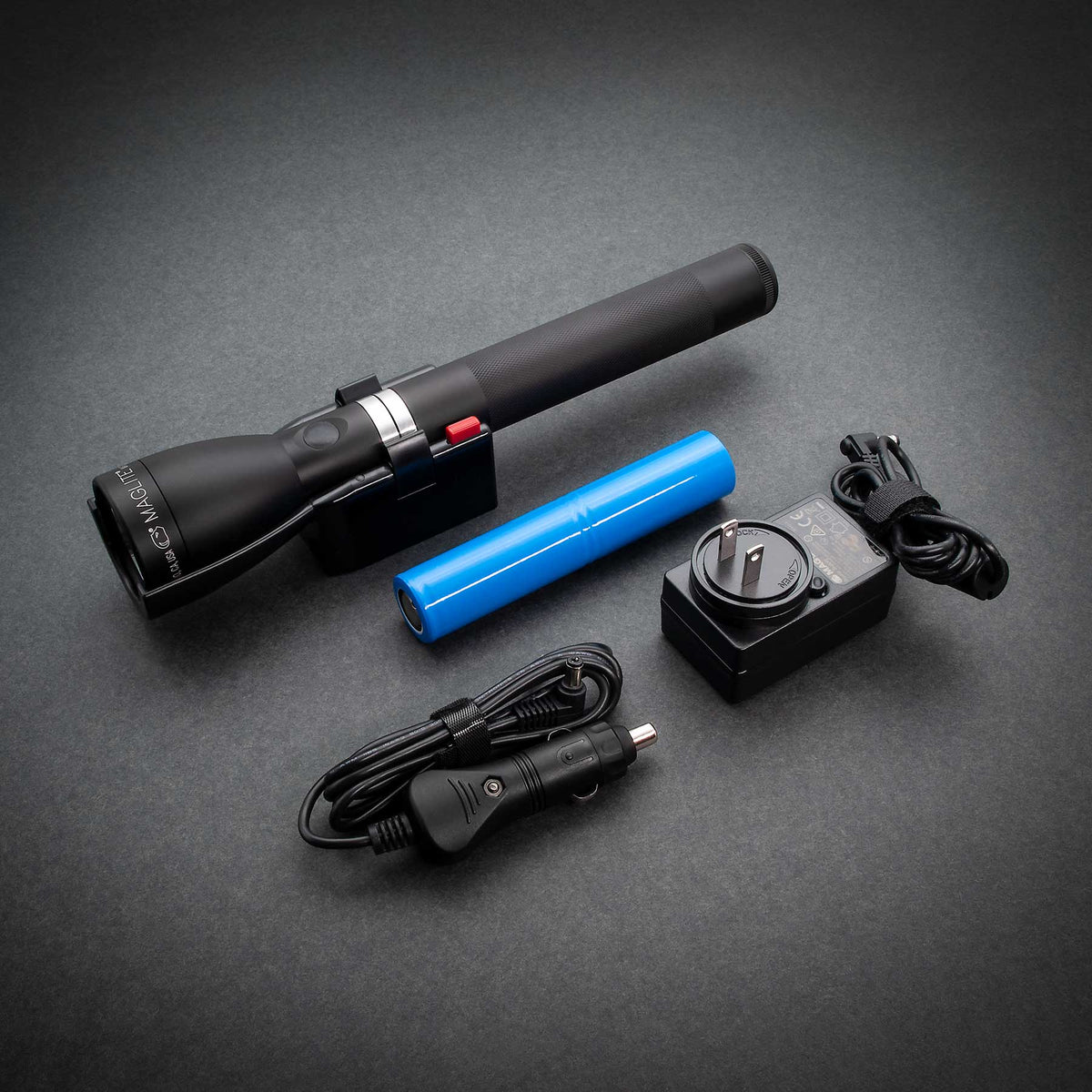 ML150LR Mag Charger flashlight resting on charging cradle with blue rechargeable battery nearby.
