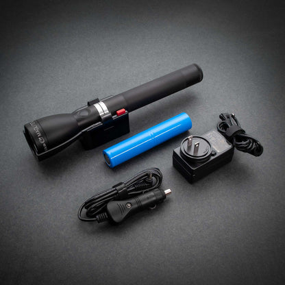 ML150LR Mag Charger flashlight resting on charging cradle with blue rechargeable battery nearby.