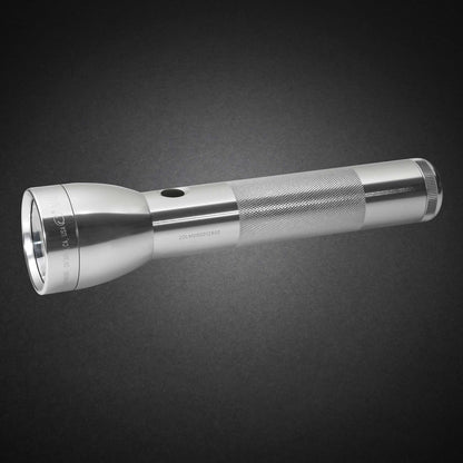 Gray ML300L LED 2-Cell D flashlight with knurled grip shown diagonally from the opposite side on a dark surface