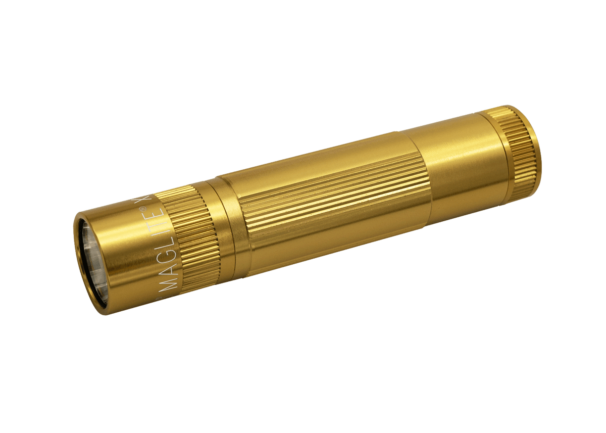 Gold Maglite XL50 LED flashlight angled across its white presentation box