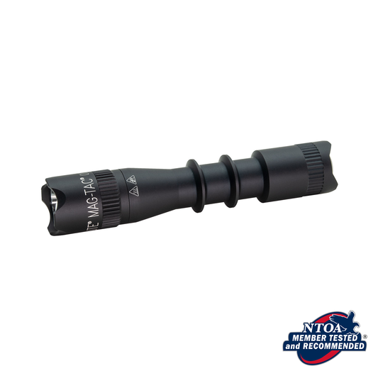 Close up of black MAG-TAC Ontario flashlight with crown bezel and NT0A badge in the corner